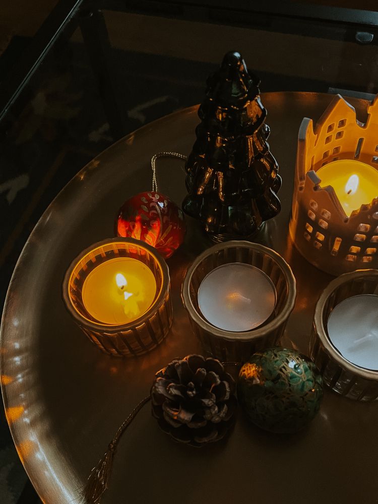 Auf einem goldenen Tablett stehen verschiedene Kerzen und Dekoration.
