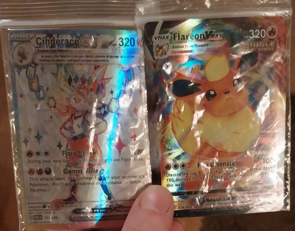zwei pokemon karten, Cinderace X und Flareon Vmax, beide in shiny/holo oder so
