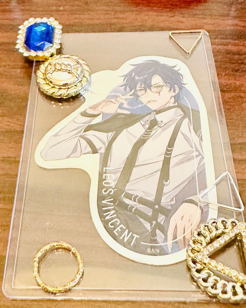 HOLIC博士のシールをデコろうとしている様子。
硬質ケースにデコパーツを仮置きして悩んでいる。