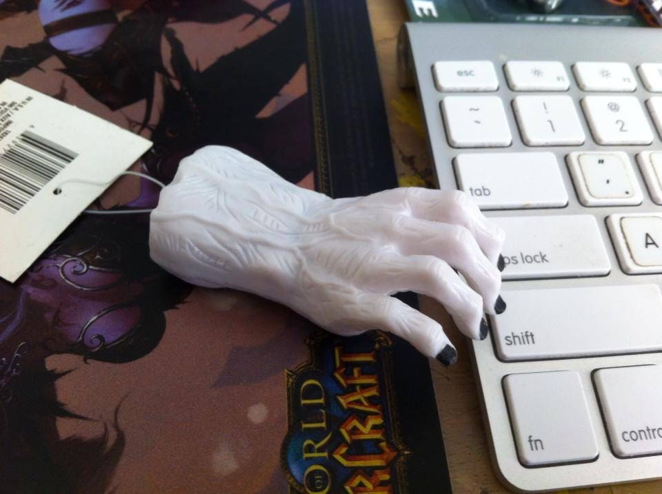 White plastic wrist and hand with prominent veins and black fingernails, about three inches from base to tip, resting on the edge of my keyboard.