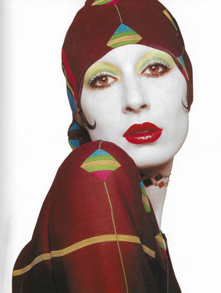 Got to be some fashion shoot her face is painted white very red lips and yellow eyeshadow yellow and blue sort of clown look there 