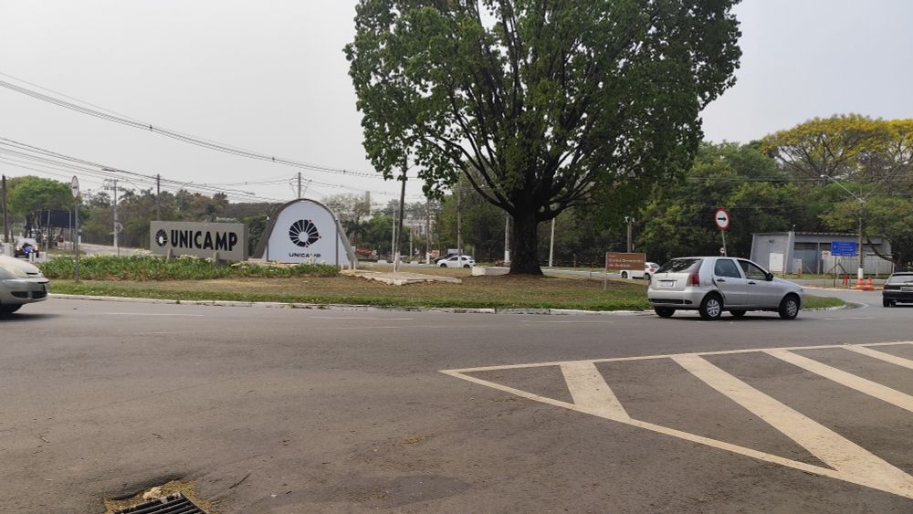 Foto de uma praça em frente a entrada principal da UNICAMP - Universidade Estadual de Campinas tirada durante o início da tarde