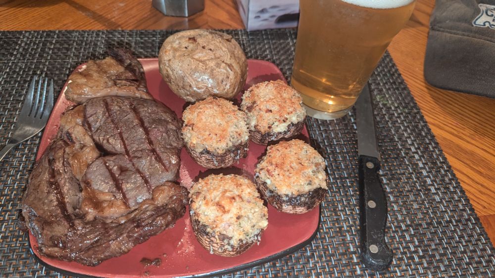 Birthday steak dinner. Grilled ribeye, baked potato, stuffed mushroom caps.