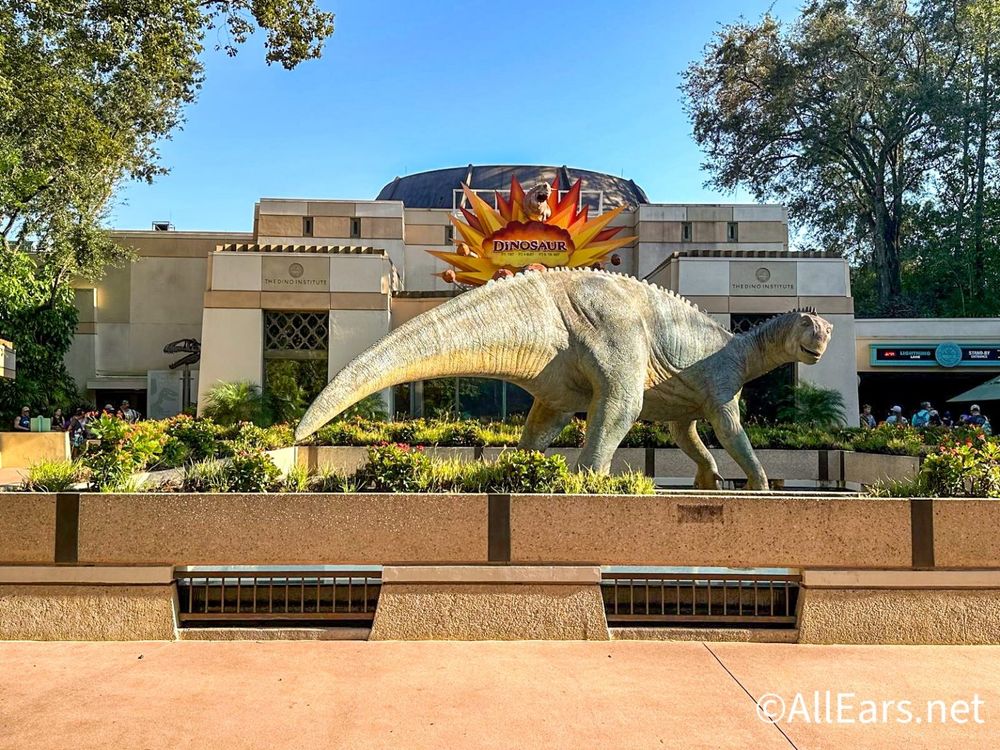 **Alt Text:** 

An image of Disney's DINOSAUR ride at Animal Kingdom, featuring the ride’s iconic dinosaur logo and a prehistoric jungle-themed backdrop. The text highlights the closure of DinoLand, U.S.A., to make way for a Tropical Americas-themed land, with a last chance to visit in 2025.