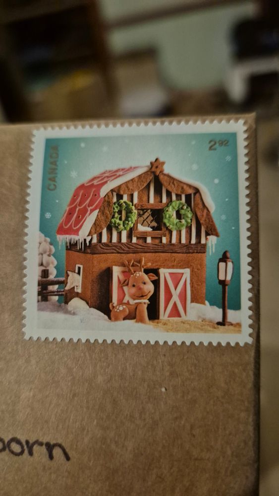 A Canadian stamp of a deer in a gingerbread house so cute 