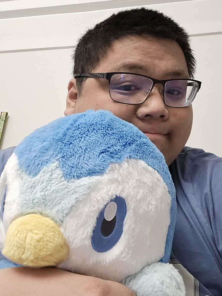 Some guy holding the softest Piplup plushie.