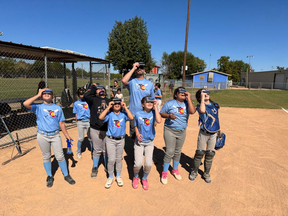 Softball players viewing partial solar eclipse