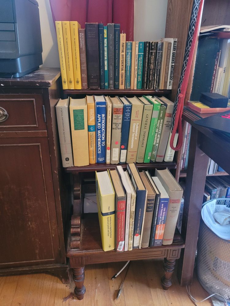 Brown wooden three step library steps, with books on them as extra shelf space