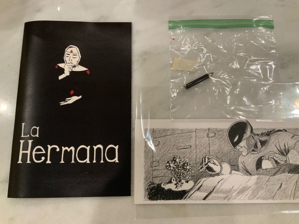 Photo of the comic book LA HERMANA, a stub of a blackwing pencil, and a drawing of Batman in a morgue examining a corpse with flowers growing from its mouth