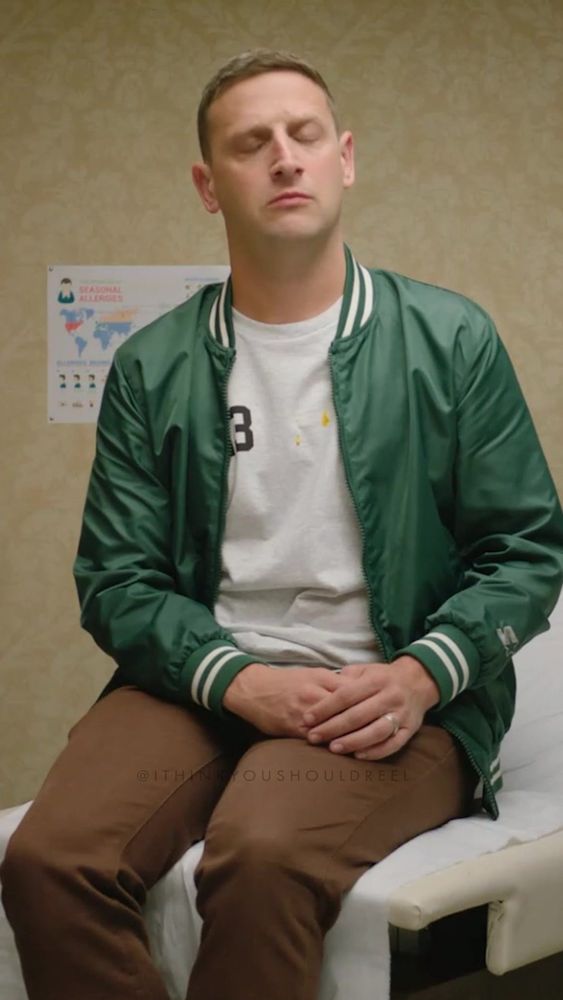 Tim Robinson sits on an exam table in a doctor’s office.