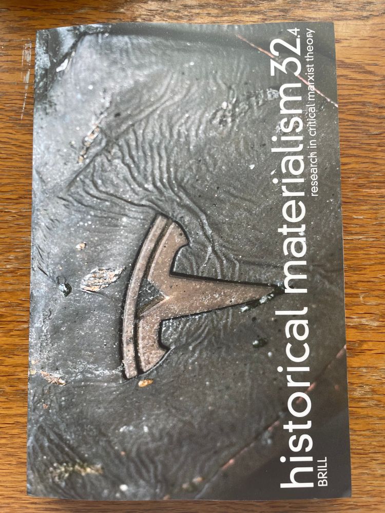 A photograph of issue 32.4 of the Historical Materialism journal. The cover image features a close-up photograph of a burnt-out Tesla car, taken in Steglitz, Berlin.