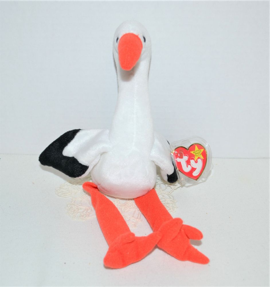 ty stilts the seagull beanie baby sitting on a little tiny off white rug propped up against a white wall