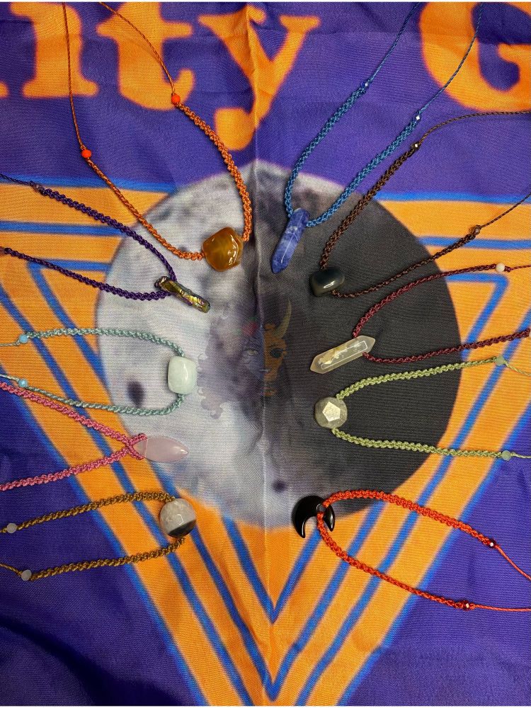 Various crystal necklaces, arranged in a half oval