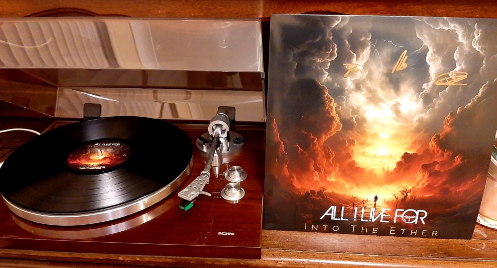 12" black vinyl LP of "Into the Ether" by All I Live For, on an ION turntable and side-by-side with the outer sleeve. 
