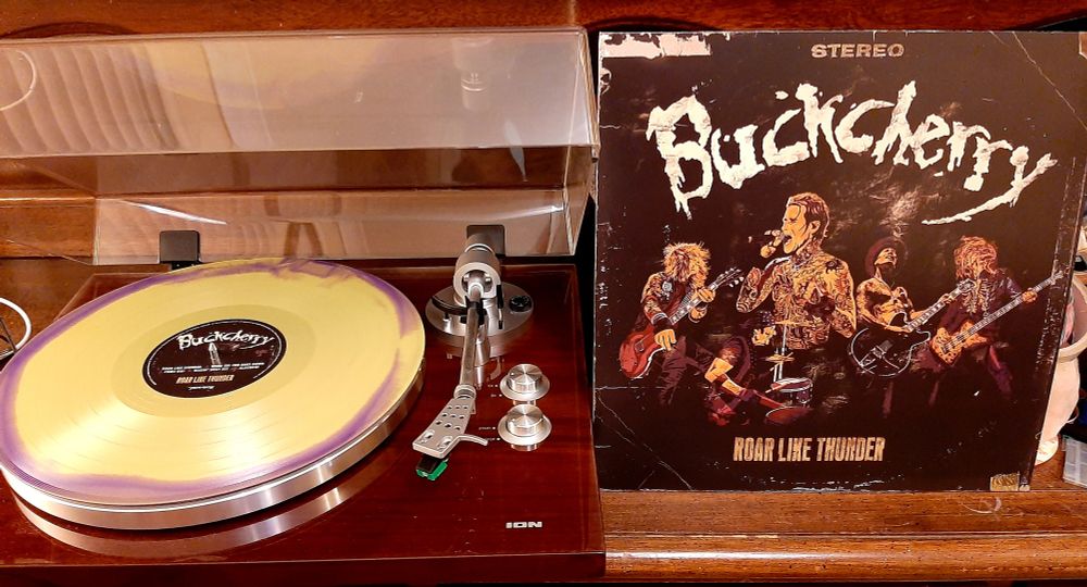 12" green & purple merge vinyl LP of "Roar Like Thunder" by Buckcherry, on an ION turntable and side-by-side with the outer sleeve. 