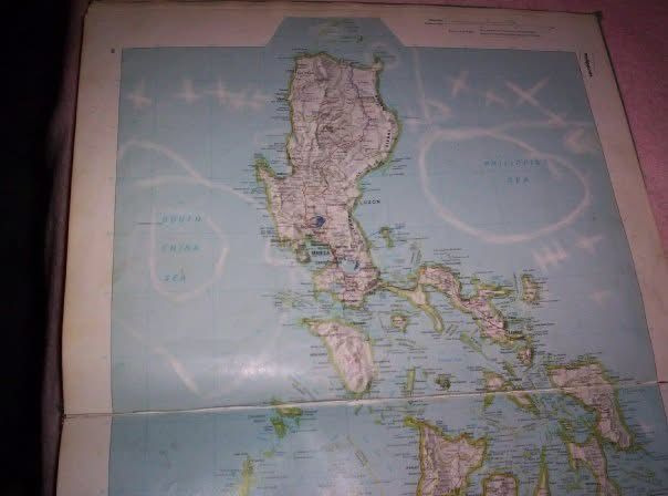 Atlas map of the Philippines circa 1988 with scribbles and marks from where a precocious child tried to draw hurricane tracks.
