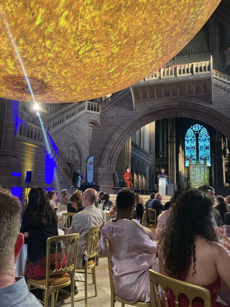 A picture of people sat for dinner in a cathedral