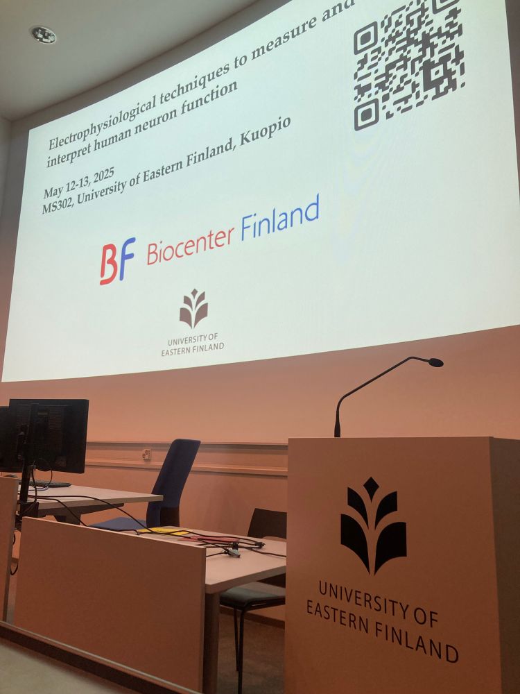 A photo of a lectern that says university of eastern Finland and behind it is a slide that says electrophysiological techniques to measure and interpret human neuron function 