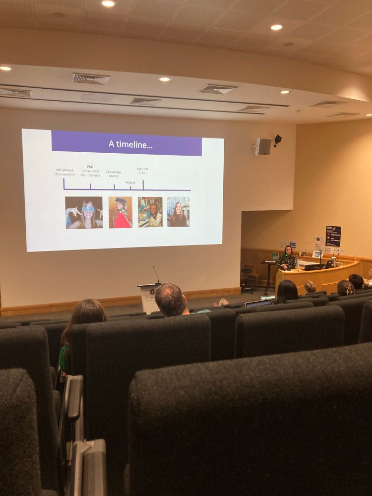 A lecture theatre with a slide that says a timeline…. Showing a small overview of Emma’s career whilst she talks about it. 
