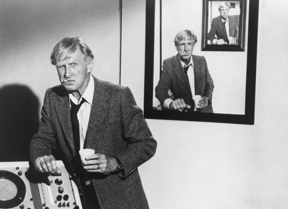 Image extraite du film Y a-t-il un pilote dans l'avion ?, sur laquelle on voit Lloyd Bridges poser devant un portrait de Lloyd Bridges posant devant un portrait de Lloyd Bridges, etc.
