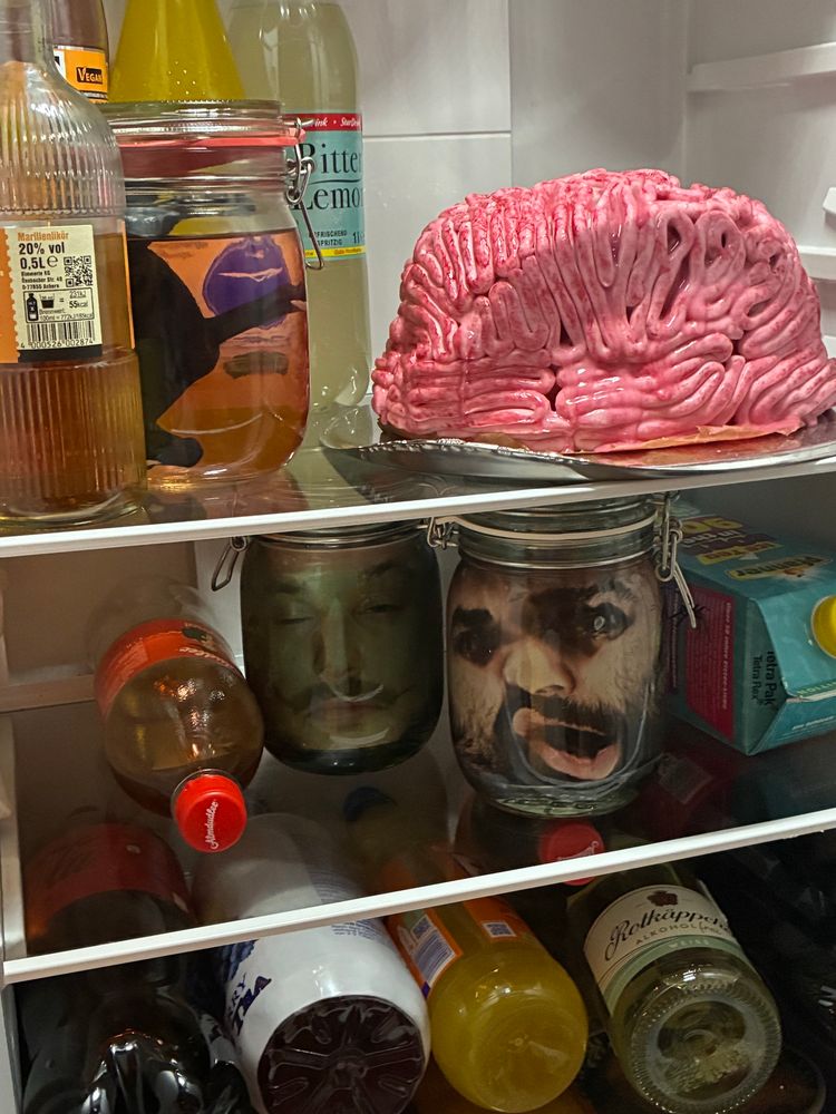 der kühlschrank von innen es gibt getränke, einen gehirnkuchen, köpfe und pferd in glas