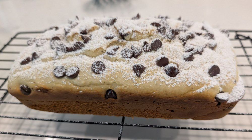 A loaf of vanilla ice cream bread with added chocolate chips and powdered sugar.  