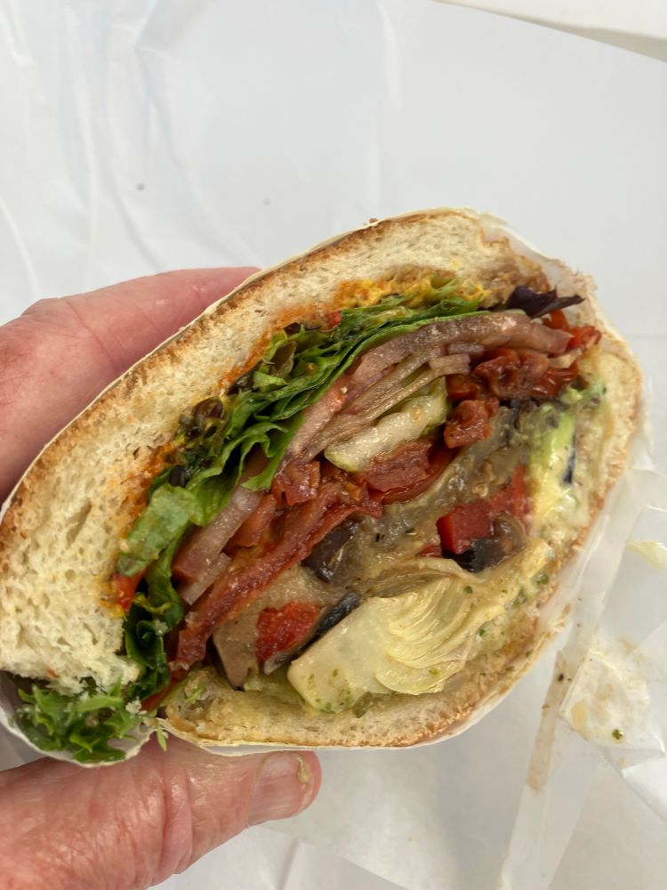 An amazing veggie sandwich w onions, tomatoes, pesto, artichoke hearts, grilled eggplant, grilled mushrooms, tapenade, oil & vinegar and more on perfect Italian roll 