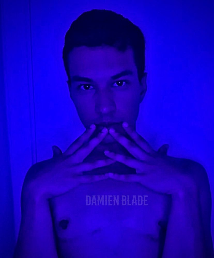 Damien Blade (he/him) poses shirtless in an indigo blue light, he is a content creator porn star ftm trans man who has Onlyfans and JustForFans account for exclusive erotic photos and videos where you can see his hot wet boy pussy and slutty ass enjoying anal fun squirting getting fucked by dildos and cocks and pumped full cum in his sexy NSFW roleplays and collabs subscribe for all his exclusive photos and videos