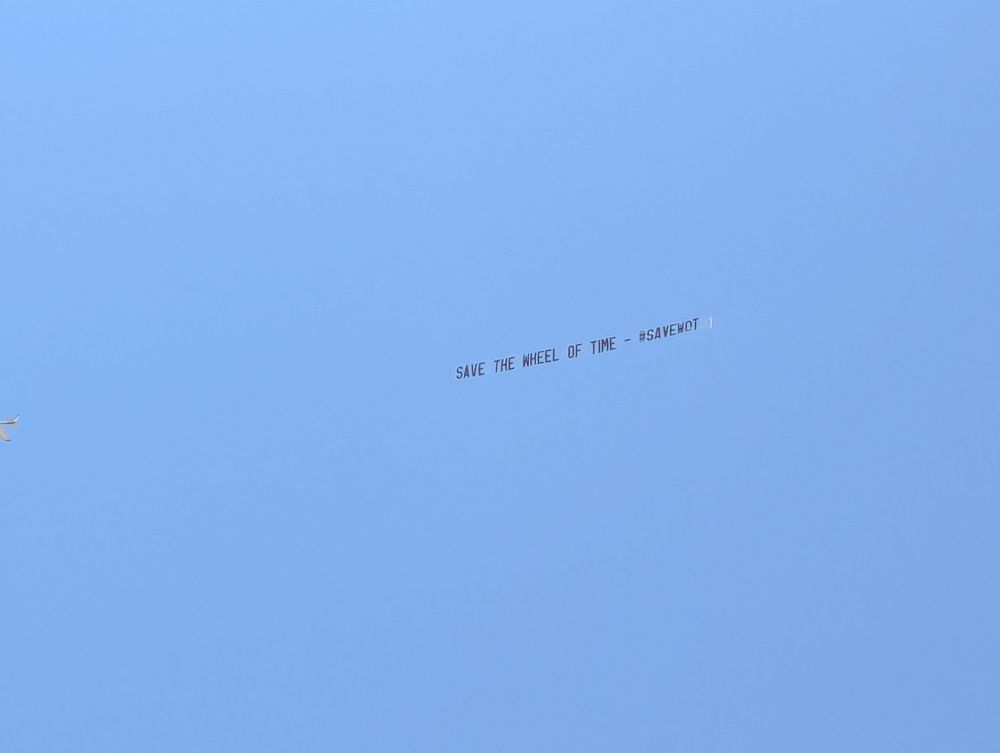 Sky banner against a blue sky that reads: Save The Wheel of Time - #SAVEWOT 