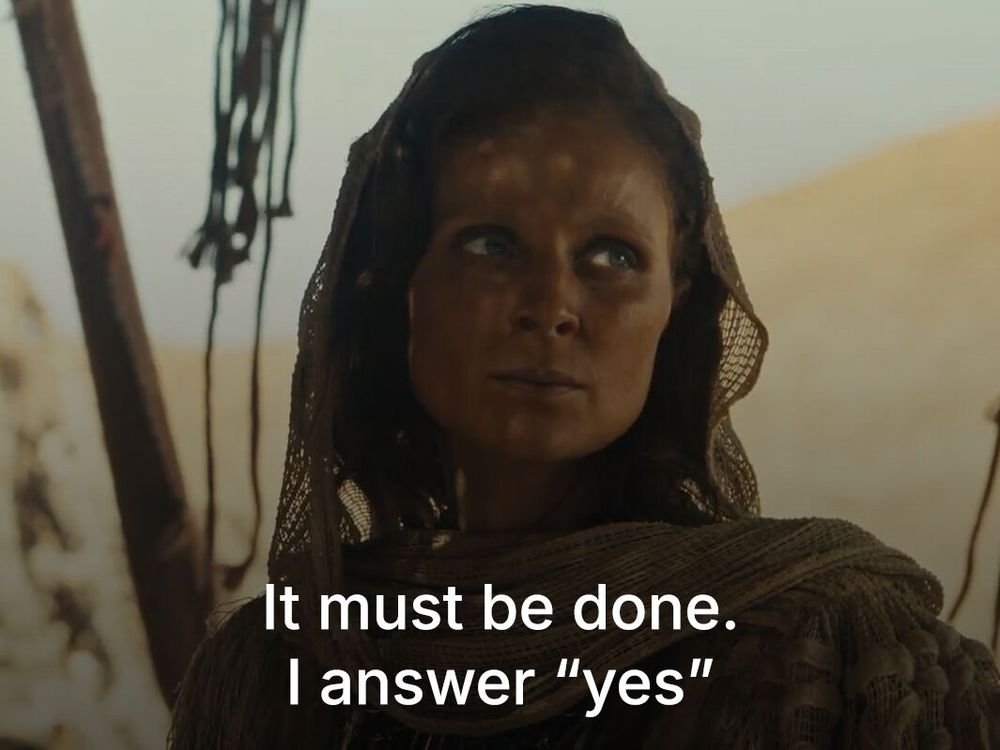 Salomé Gunnarsdóttir as Melaine, dressed in Aiel attire with a netted shawl and head covering, gazing forward with a serious look. The subtitle reads: “It must be done. I answer ‘yes.’”