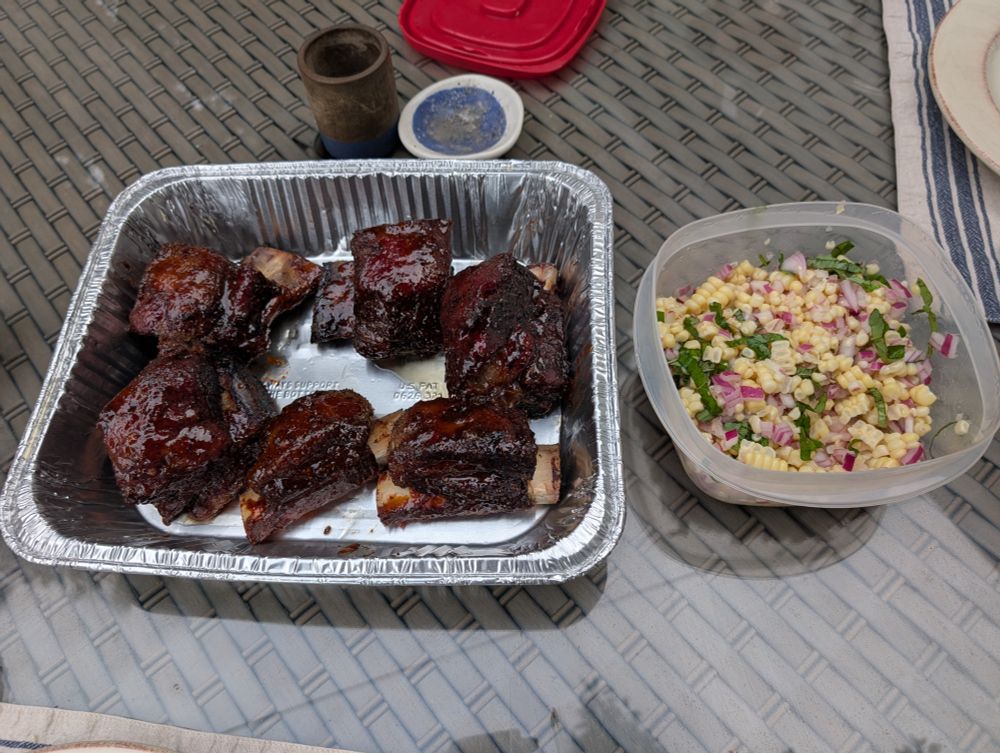 Smoked Korean short rib next to fresh corn salad with red onion and basil