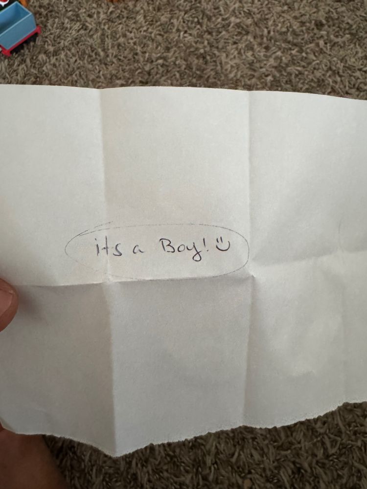 A piece of paper saying “it’s a boy” written by the ultrasound tech