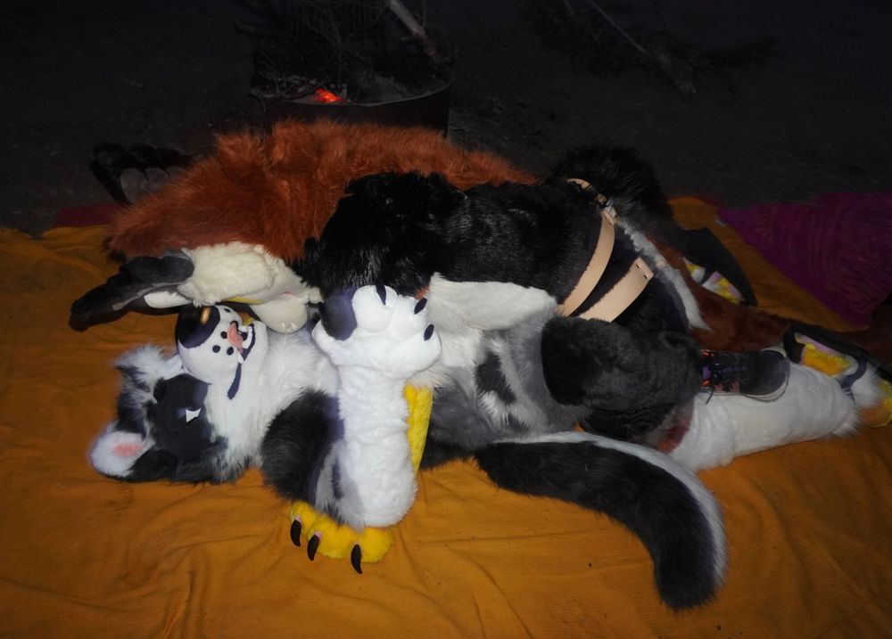 An alternate view of the previous scene. Vec’s hips are nestled between Kaspers open legs, the dragon’s leather strap harness now visible. A camp fire pit is visible in the background.