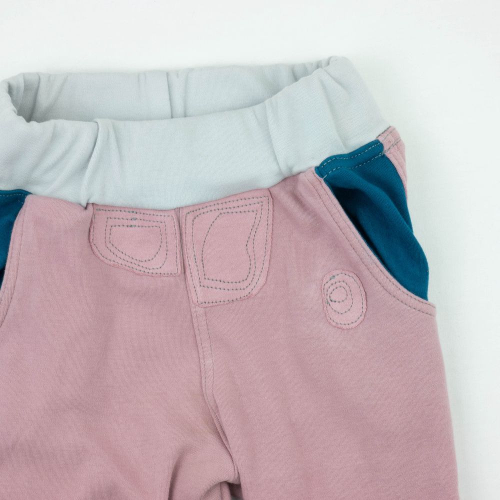 Purple pants with blue pockets. Topographic inspire visibly mended patches on the front of pants.