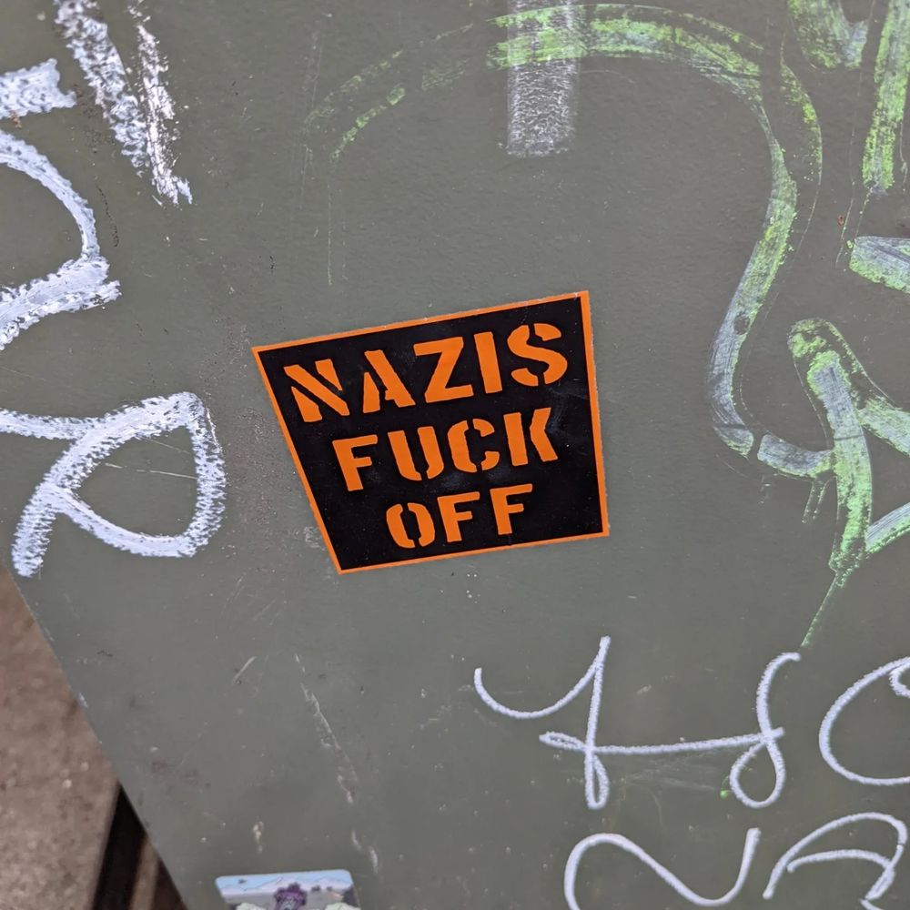  A sign on a wall that says nazis fuck off.