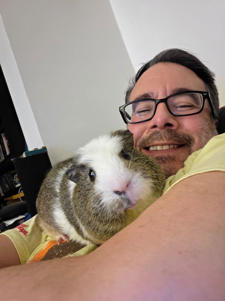 Selfie with my guinea pig Bob sitting on my chest while we rest on the couch