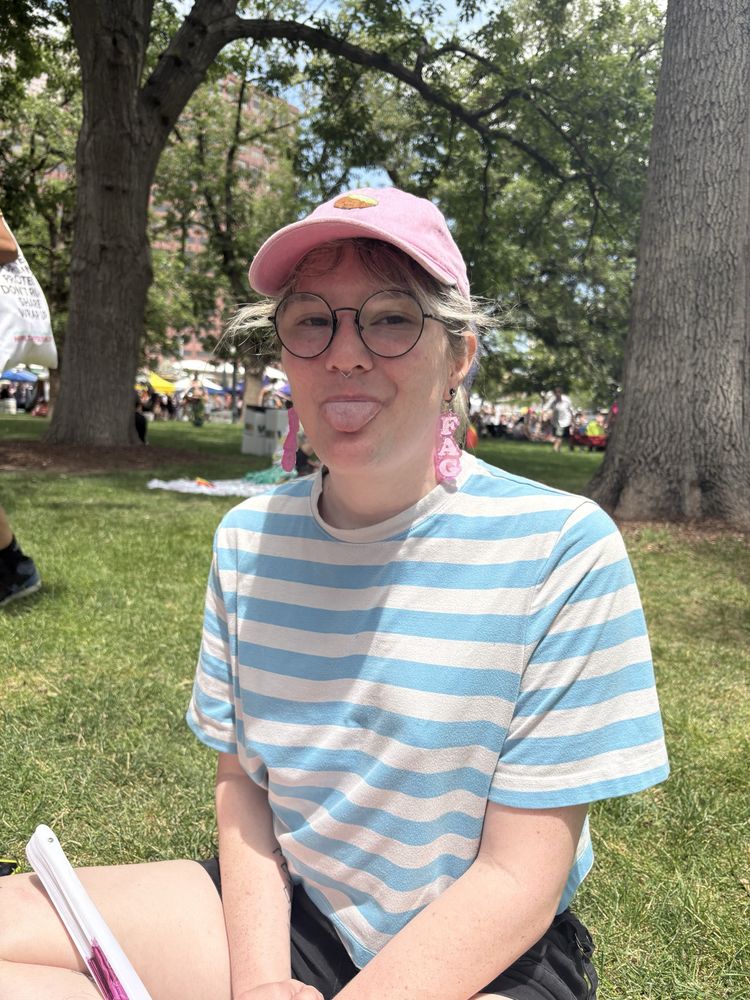 jaiden sitting in a park with her tongue out