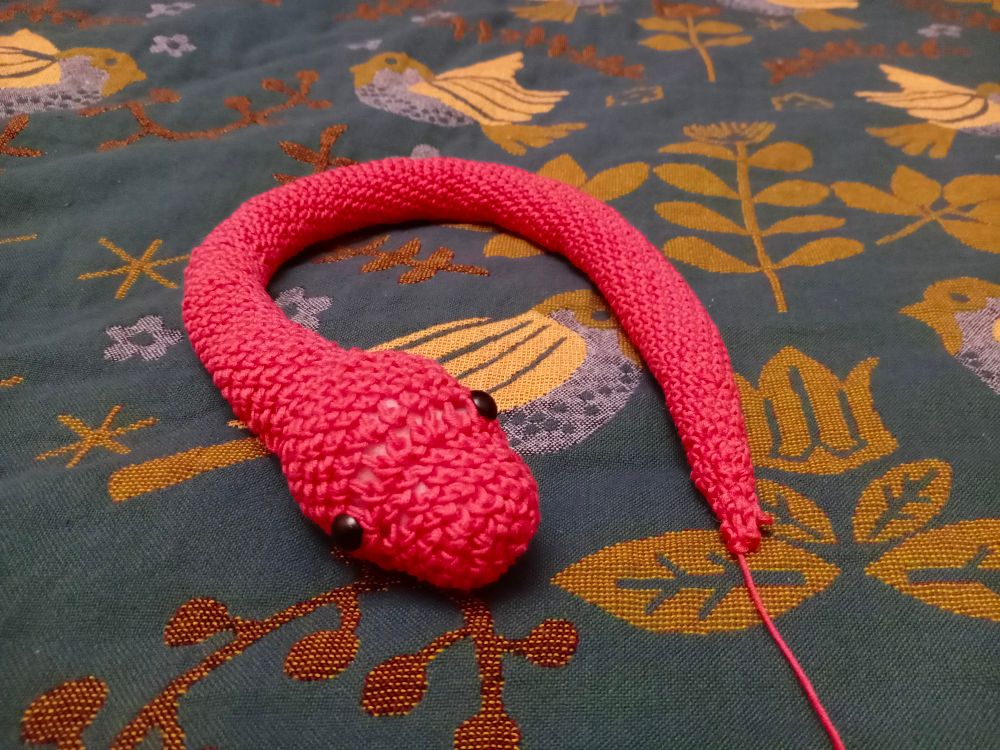 A pink crochet snake