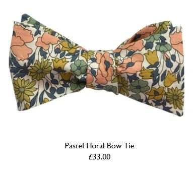 A tied bow tie. The pattern is a white background with pink, salmon, green and mustard coloured flowers. Below the bow tie, it's title; "Pastel Floral Bow Tie £33". 