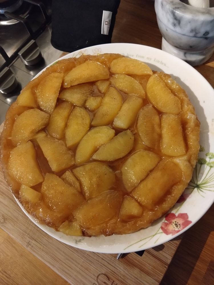 A plate with what seems like slices of apples in a caramel coloured caramel sauce. 