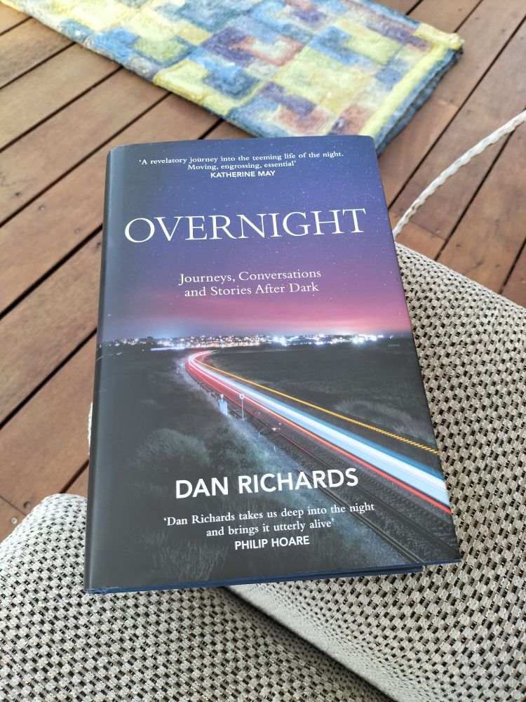 Overnight, Journeys, Conversations and Stories After Dark, by Dan Richards.

There is something special about the night. For many, just the idea of it conjures thoughts of starlit skies, romance, refuge, of being tucked up in bed. For some, the night means fear, vulnerability, danger, sleeplessness. For others still, nightfall signals the start of work. At night things go bump, monsters hide under beds, owls take wing and foxes prowl.Overnight is a celebration of all things nocturnal, of those who labour while the rest of us sleep: the bakers, health workers, sailors, couriers, broadcasters, drivers, fishers, the men and women of the emergency services and more. And it is also a hymn to nighttime wildlife, dreams and art. We'll hang out with bats and look at the stars. We'll learn what Moomintroll has to teach us about insomnia. We'll travel by ship, train, racing car and foot. There will be more than one surprise along the way.Through a series of personal journeys Dan Richards explores what the night means to a fascinating array of people, taking us from night terrors to the glow of watching the dawn break on the summer solstice. Overnight will change the way you think about the hours after dark.