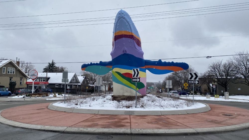 A photo of Salt Lake City's whale sculpture. It's a multicolored whale in the middle of a roundabout.