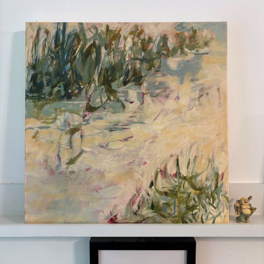 A painting sitting on a shelf featuring expensive calligraphic marks in greens and blues on a pale cream colored ground where bits of red and pink pop through suggesting a marsh like landscape. 