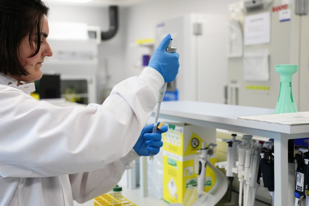 Lab technician using a pipet and test tube. 