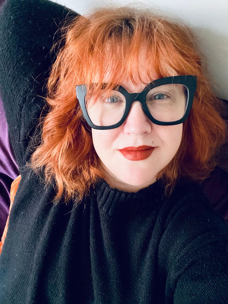 Redhead lady in giant glasses and a huge sweater 