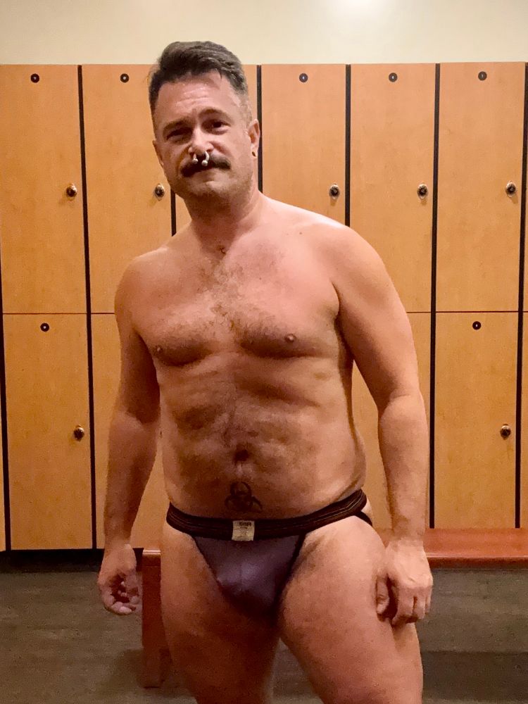 Man in gym locker room wearing purple BIKE jockstrap