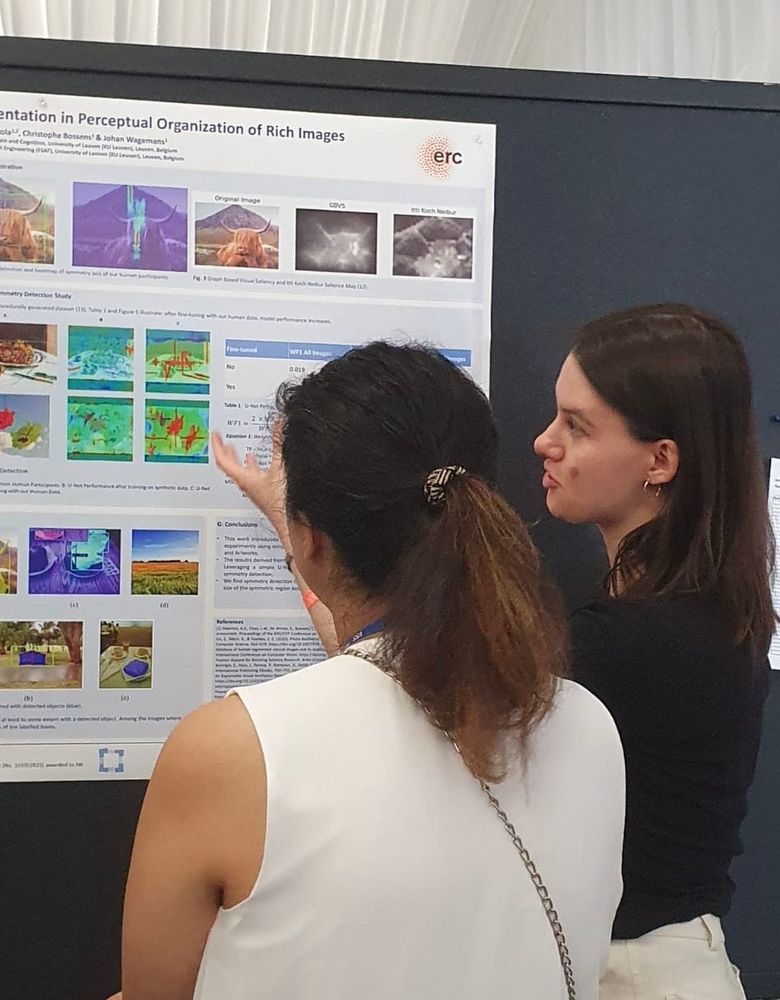 Two people standing in front of a research poster.