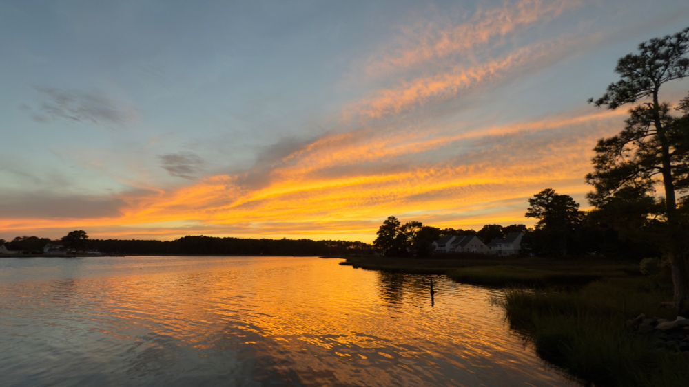 The sun has disappeared below the horizon leaving the clouds glowing in orange light.