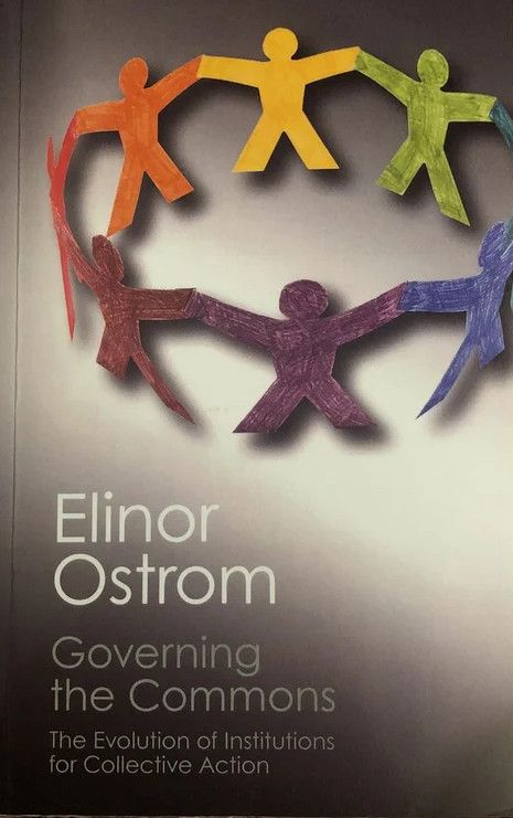 Governing the Commons: The Evolution of Institutions for Collective Action by Elinor Ostrom.  A Gray cover with the title and author in white. The cover art is a ring of paper doll cutouts in several colors, red, orange, green, blue, purple and magenta.