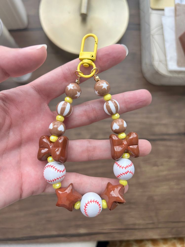 A padres themed bag chain with brown and yellow beads 